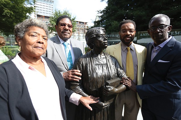 Relatives of Virginia Estelle Randolph, a noted educator in Henrico County who was named the first Jeanes Foundation Supervising Industrial Teacher in the United States, stand around her bronze statue after Monday’s ceremony. They are, from left, Henrietta McMickens of Richmond, Ms. Randolph’s great-niece; Nelson Randolph Lawson of Richmond, Ms. Randolph’s adopted nephew; and Willie Dean Jr. of Schenectady, N.Y., Ms. Randolph’s great-great-nephew; and Michael Davis of Richmond, Ms. Randolph’s great-great-great-nephew.