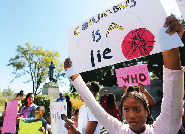 Kennedy Wright, 9, holds a sign protesting Columbus Day during a rally at the Columbus statue in Byrd Park on Monday. The protest, led by members of the Cultural Roots Homeschool Co-op, also urged removal of the statue that is situated at the south end of Arthur Ashe Boulevard. The protest was on Monday, Oct. 14, which had been designated by Richmond Mayor Levar M. Stoney as Indigenous Peoples’ Day to honor the contributions native people who were displaced and destroyed as a result of European invasion by people such as Christopher Columbus. The home school cooperative has a curriculum that emphasizes the black diaspora including Caribbean, Central and South/ North America’s indigenous peoples.(Regina H. Boone/Richmond Free Press)