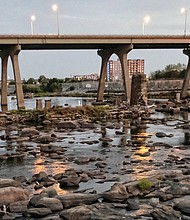 Rocks typically covered by the rushing waters of the James River are now visible because of low water levels. This view of the river, taken Tuesday evening near the Manchester Bridge, is emblematic of the severe drought that has gripped much of Virginia in the past two months.
The river has dropped below four feet in height and its flow is below normal, according to the U.S. Geological Survey, which monitors the James River. The rain last Sunday was welcome, but its impact had dissipated within two days, the USGS data show. More rain on Wednesday also provided relief, but experts indicate it will take regular rain to make up the deficit in moisture that has developed. Some areas of the state are reportedly seven inches below normal rainfall levels. Concerned about the river that is a main source of drinking water for the Richmond area, city and county public utility departments are urging area residents to take voluntary conservation efforts, including reducing watering lawns and washing vehicles.