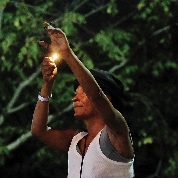 Lots of music/lots of folk/Richmond’s Downtown riverfront came alive with people and music last weekend as thousands of people turned out for the Richmond Folk Festival. One audience member shows her appreciation by shining a light. (Sandra Sellars/Richmond Free Press)