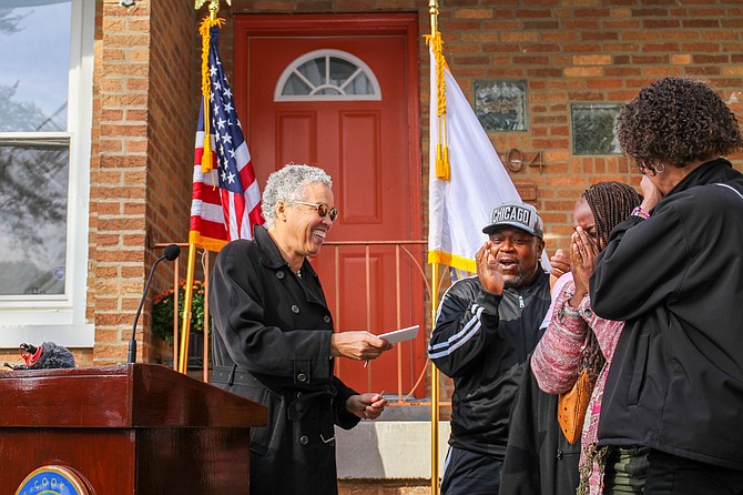 Cook County Board President Toni Preckwinkle hands over the key to the house to its new owner, Vanesssa Johnson, who is crying tears of joy.