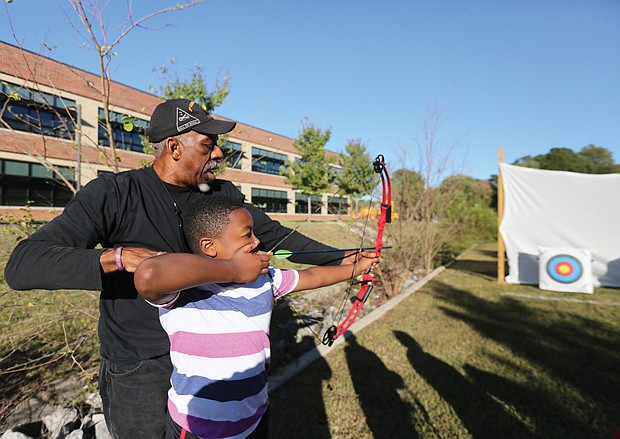Aiming for the target: Josh Morris, a fourth-grader at Broad Rock Elementary School in South Side, learns how to set his arrow in a bow to accurately hit the target during an after-school program last Friday with recreation specialist Wyatt Kingston of the Richmond Department of Parks, Recreation and Community Facilities. Mr. Kingston, who beame certified to teach archery more than a decade ago, gives group and individual instruction to youngsters. He was working last week with students at the Broad Rock Community Center, and will rotate among the various recreation centers in Richmond. His ultimate goal, he said, is to build the skills of youngsters to the point that they can compete in local and state competitions.