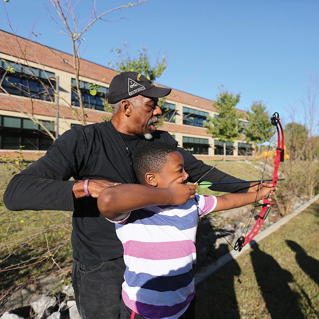 Aiming for the target: Josh Morris, a fourth-grader at Broad Rock Elementary School in South Side, learns how to set his arrow in a bow to accurately hit the target during an after-school program last Friday with recreation specialist Wyatt Kingston of the Richmond Department of Parks, Recreation and Community Facilities. Mr. Kingston, who beame certified to teach archery more than a decade ago, gives group and individual instruction to youngsters. He was working last week with students at the Broad Rock Community Center, and will rotate among the various recreation centers in Richmond. His ultimate goal, he said, is to build the skills of youngsters to the point that they can compete in local and state competitions.