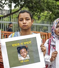 Bangladeshi women hold placards and photographs of schoolgirl Nusrat Jahan Rafi at a protest in Dhaka on April 12, 2019.