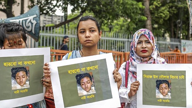 Bangladeshi women hold placards and photographs of schoolgirl Nusrat Jahan Rafi at a protest in Dhaka on April 12, 2019.