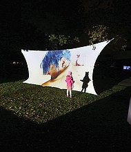 A youngster is intrigued by her shadow on an art installation at Chimborazo Park last Friday and Saturday as part of 1708 Gallery’s InLight 2019, an annual exhibition of light-based art and performances. About 20 pieces were at the free, two-day, outdoor exhibit in Church Hill focused on the social and geographic history of the park, which served as one of the largest Confederate military hospitals during the Civil War and afterward a community for formerly enslaved people. The installation the youngster enjoyed is “Pieces of Us” by Allicette Torres.