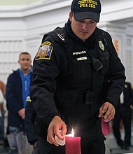 Chesterfield Police Officer William Spencer lights a candle as area residents participate in Mothers Against Drunk Driving Virginia’s annual Candlelight Vigil of Remembrance and Hope on Monday night. The event, held at the Lewis Ginter Botanical Garden’s Robins Visitors Center because of the rain, is to remember and honor those who have lost their lives to drunk drivers.