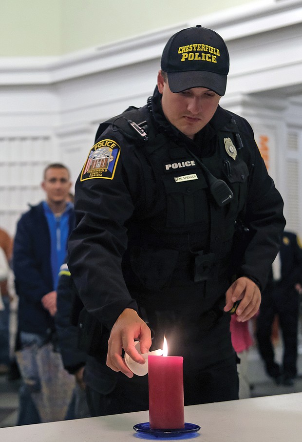 Chesterfield Police Officer William Spencer lights a candle as area residents participate in Mothers Against Drunk Driving Virginia’s annual Candlelight Vigil of Remembrance and Hope on Monday night. The event, held at the Lewis Ginter Botanical Garden’s Robins Visitors Center because of the rain, is to remember and honor those who have lost their lives to drunk drivers.