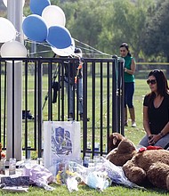 Mirna Herrera kneels with her daughters Liliana, 15, and Alexandra, 16, at the Central Park memorial last Friday for the Saugus High School victims in Santa Clarita, Calif. Investigators said they have yet to find a diary, manifesto or note that would explain why Nathaniel Tenosuke Berhow killed two students outside his Southern California high school on his 16th birthday.