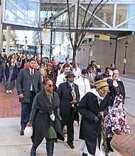 Queen Nzinga of Richmond leads a procession of Virginia Commonwealth University officials, students and others as they welcomed and paid their respects as the remains were returned to the VCU medical campus. Elegba Folklore Society members poured libations honoring those whose remains were returned during a ceremony in the courtyard of the Hermes A. Kontos Medical Sciences Building at 12th and Marshall streets. The remains were found in a well during the 1994 construction of the building.