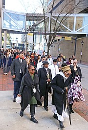 Queen Nzinga of Richmond leads a procession of Virginia Commonwealth University officials, students and others as they welcomed and paid their respects as the remains were returned to the VCU medical campus. Elegba Folklore Society members poured libations honoring those whose remains were returned during a ceremony in the courtyard of the Hermes A. Kontos Medical Sciences Building at 12th and Marshall streets. The remains were found in a well during the 1994 construction of the building.