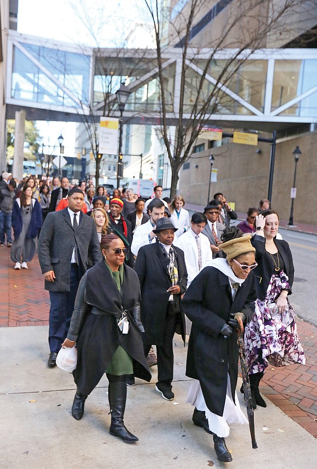 Queen Nzinga of Richmond leads a procession of Virginia Commonwealth University officials, students and others as they welcomed and paid their respects as the remains were returned to the VCU medical campus. Elegba Folklore Society members poured libations honoring those whose remains were returned during a ceremony in the courtyard of the Hermes A. Kontos Medical Sciences Building at 12th and Marshall streets. The remains were found in a well during the 1994 construction of the building.