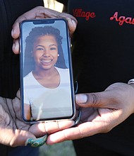 Kele A. Wright and Shavon M. Ragsdale hold a photo of Ms. Wright’s daughter, Amiya Moses, 12, who was killed by a stray bullet in December 2015 as she played with other youngsters in North Side. Both women have lost loved ones to gun violence.