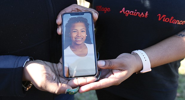 Kele A. Wright and Shavon M. Ragsdale hold a photo of Ms. Wright’s daughter, Amiya Moses, 12, who was killed by a stray bullet in December 2015 as she played with other youngsters in North Side. Both women have lost loved ones to gun violence.