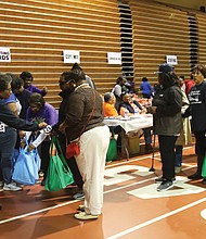 Because of the volunteer effort, hundreds of people moved smoothly through the line at the Arthur Ashe Jr. Athletic Center to take home turkeys, canned goods and the trimmings for Thanksgiving.