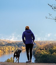 A woman and her dog pause to drink in an iconic view of the James River from Libby Hill Park in the East End. Legend has it that the city’s founder, William Byrd II, named Richmond after the English borough of Richmond-upon-Thames because the bend of the James River at this vantage point reminded him of the Thames River in its passage through that London suburb. No evidence has ever turned up to support the story.