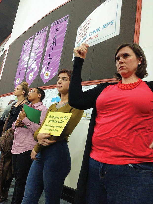 Parents hold signs at the Richmond school rezoning public hearing Monday night at Bellevue Elementary School signifying their support for school integration and diversity, along with a desire that the money needed to pair schools to achieve diversity be used to boost student instruction.