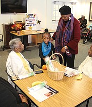 Delegate Delores L. McQuinn, standing, and her 6-year-old grand-daughter Storie Znassi deliver fruit baskets and body lotion to residents of the Darby House senior apartment community in Henrico County last Friday for “I Am My Brother and Sister’s Keeper Day.” The special statewide designation for the day after Thanksgiving was approved by the General Assembly in 2018 by a resolution introduced by Delegate McQuinn. It asks Virginians to perform a random act of kindness on the Friday after the holiday. On this second annual “I Am My Brother and Sister’s Keeper Day,” Delegate McQuinn challenged people to have seven others join in doing something kind to make a difference in the lives of others. She and her granddaughter visit here with, from left, Ethel Davis, 81, Doris Laidler, 71, and Mary Berryman, 88. Other participants out doing kind acts for others on the special day included members of Delegate McQuinn’s legislative staff and members of the Richmond police and fire departments.
