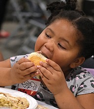 Sasha Northan, 4, takes a bite from a dinner roll.
