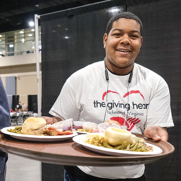 Hundreds of people came together last Thursday to enjoy The Giving Heart’s annual free Community Thanksgiving Feast at the Greater Richmond Convention Center in Downtown. The feast of turkey and stuffing and all the trimmings was supported by the donations of time, food and money of hundreds of individual and corporate volunteers who made it a real success. Damarious Banks, 15, was among the young adults serving meals to the hungry crowd.