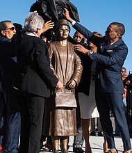 Montgomery, Ala., Mayor Steven Reed, right, and Alabama Gov. Kay Ivey, front left, work with others to unveil the statue of civil rights icon Rosa Parks in downtown Montgomery last Sunday, the anniversary of her 1955 arrest for not giving up her seat on a public bus.