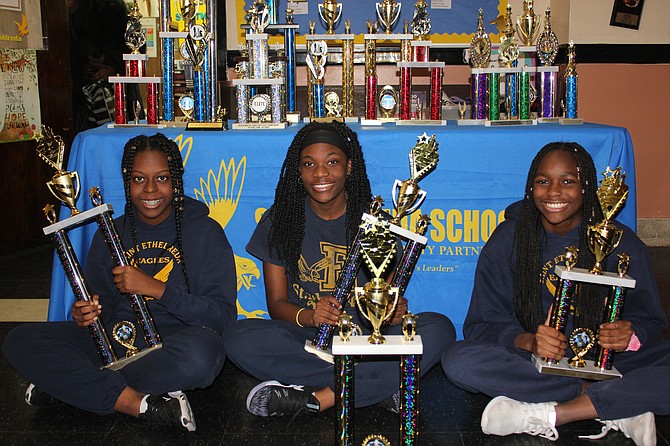 (from left) Shakira Luster, Trechelle Williams and Imani Hill, three eighth graders at St. Ethelreda School, 8734 S. Paulina Ave., proudly show off their state chess trophies they won at last month’s state chess championship. Photo credit: By Wendell Hutson