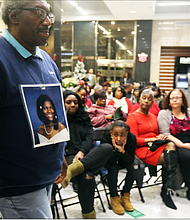 John Burnley of Richmond, below, wears a photo of his late daughter, Juanita Burnley, during the Coalition Against Violence’s 29th Annual Holiday Memorial Service to remember those who lost their lives to violence in the city. Relatives, friends and supporters mourning lost loved ones who were victims of violence at- tended the Dec. 12 ceremony held in the lobby of Richmond City Hall. Participants wrote the names of their loved ones on red ribbons that
were placed around the statue, “River of Tears,” that stands situated in City Hall. Mr. Burnley’s daughter was murdered by her boyfriend in No- vember 2007, and he has annually attended the memorial started by Linda Jordan to help family members with their grief and loss through the holidays.