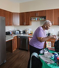 Ms. Ward unpacks groceries in her new kitchen, while Ms. Cavell shows off her new living room and bedroom. The two, who had lived for 35 years in the nearby Creighton Court public housing community are among 37 seniors from Creighton Court who have moved into the newly completed building as part of the first step to redeveloping the public housing complex. The Community Builders of Boston undertook the Armstrong Renaissance development with the Richmond Redevelopment and Housing Authority.