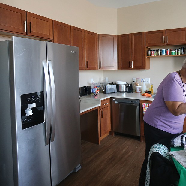 Ms. Ward unpacks groceries in her new kitchen, while Ms. Cavell shows off her new living room and bedroom. The two, who had lived for 35 years in the nearby Creighton Court public housing community are among 37 seniors from Creighton Court who have moved into the newly completed building as part of the first step to redeveloping the public housing complex. The Community Builders of Boston undertook the Armstrong Renaissance development with the Richmond Redevelopment and Housing Authority.