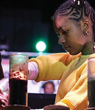 Kiante Tate, 12, lights one of the seven candles of the kinara at the annual Capital City Kwanzaa Festival last Saturday. The event, held at Martin Luther King Jr. Middle School by the Elegba Folklore Society, drew hundreds of people honoring the seven principles highlighted during Kwanzaa’s seven days. Kwanzaa was founded in 1966 in the United States by Dr. Maulana Karenga.