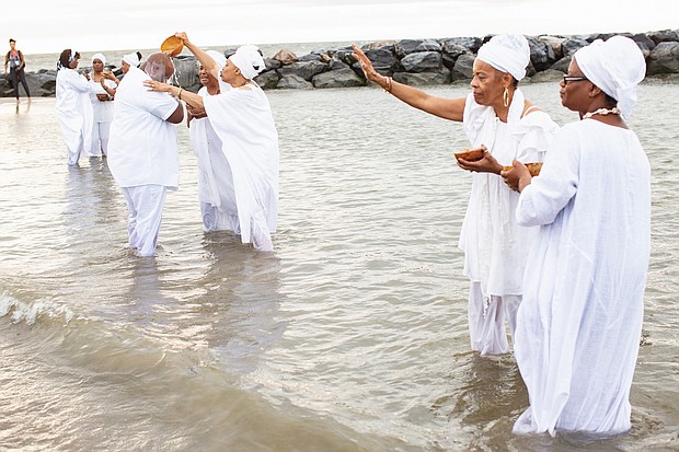 Queen mothers from the Institute of Whole Life Healing in Kentucky anoint people during a sunrise cleansing and healing ceremony at Buckroe Beach in Hampton as part of the August events commemorating the 400th anniversary of the first Africans arriving via slave ships in English North America.