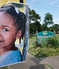 A flier bearing the picture of Markiya Dickson, 9, is posted near an entrance to Carter Jones Park where the third-grader was shot and killed at a community cookout during Memorial Day weekend.