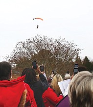 Three members of the Women’s Skydiving Network parachute into Lewis Ginter Botanical Garden Tuesday morning to the clicks of dozens of cell phone cameras as they helped launch the Women’s Equality Legislative Summit.