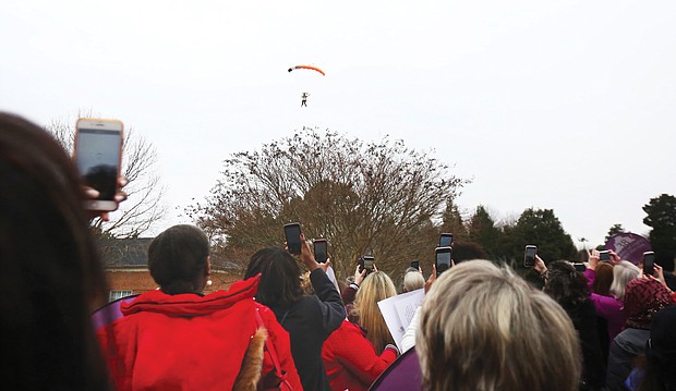 Three members of the Women’s Skydiving Network parachute into Lewis Ginter Botanical Garden Tuesday morning to the clicks of dozens of cell phone cameras as they helped launch the Women’s Equality Legislative Summit.