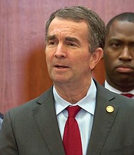 Gov. Ralph S. Northam, center, is given a unified show of support during Wednesday’s news conference by State Police Superintendent Gary Settle, left, Richmond Mayor Levar M. Stoney and other state law enforcement officials.