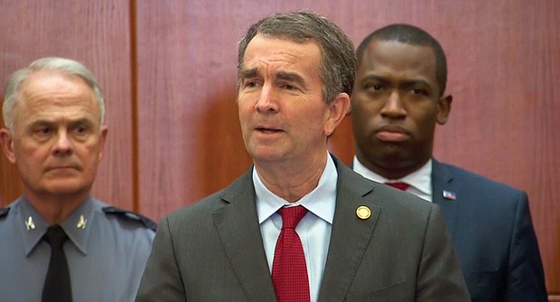 Gov. Ralph S. Northam, center, is given a unified show of support during Wednesday’s news conference by State Police Superintendent Gary Settle, left, Richmond Mayor Levar M. Stoney and other state law enforcement officials.