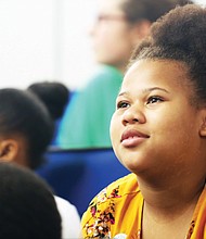 Fourth-grader Aneja Hutcherason listens closely as Ms. Schrier, a graduate student at the VCU School of Pharmacy, talks about science, taking risks and success.