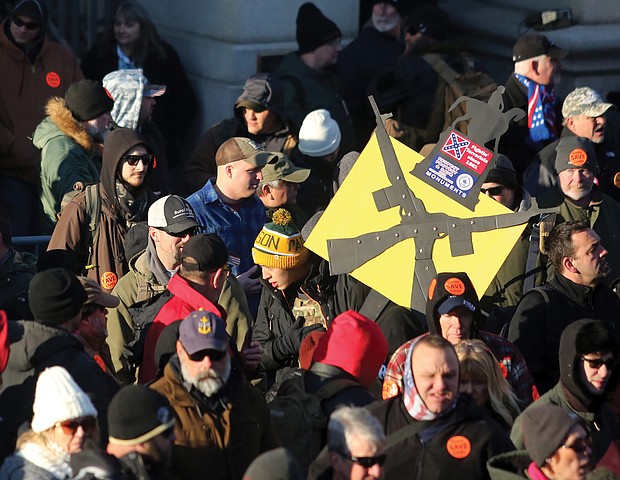 A Confederate flag is emblazoned on a sign carried by demonstrators at the gun rights rally.