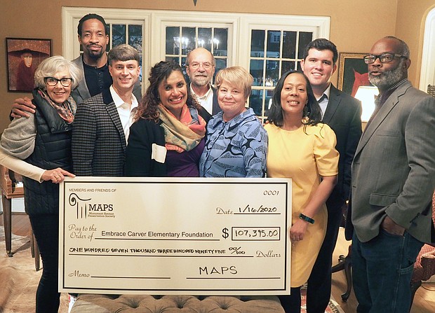 Supporters of Carver Elementary School present a check for $107,395 to school Principal Tiawana Giles, third from right. Making the presentation, from left, are Jean Estes, Billy McMullen, Bill Gallasch, Edward Barlow, 2nd District City Councilwoman Kim B. Gray, Embrace Carver Elementary Foundation President Deborah Corliss, 2nd District School Board member J. Scott Barlow and Carver Area Civic Improvement League President Jerome Legions.