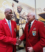 Rep. A. Donald McEachin of Richmond, left, is congratulated by Howard L. Baugh of Portsmouth after the con- gressman was made an honorary Tuskegee Airman during a ceremony last Saturday by the Howard Baugh Chapter of Tuskegee Airmen Inc. in Petersburg. Mr. Baugh is the oldest son of the late Lt. Col. Howard Baugh of Petersburg who was one of the famed airmen of the 99th Pursuit Squadron and the 332nd Fighter Group that escorted bombers on combat missions over Europe during World War II. Lt. Col. Baugh was honored during his lifetime with numerous commendations, including the Distinguished Flying Cross, the Air Medal with three Oak Leaf Clusters and the U.S. Air Force Commendation Medal, along with the French Legion of Honor Award bestowed by the French government. The ceremony was held at the Richmond Executive Airport in Chesterfield County. The Petersburg group is one of 56 Tuskegee Airmen chapters in the United States dedicated to honoring the accomplishments and preserving the legacy of the airmen who trained at the Tuskegee
Army Air Field in Alabama.