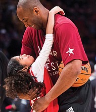 Kobe Bryant hugs his daughter, Gianna, on the basketball court during warm-ups before an NBA All-Star Game in Toronto on Feb. 14, 2016.