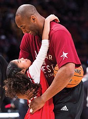 Kobe Bryant hugs his daughter, Gianna, on the basketball court during warm-ups before an NBA All-Star Game in Toronto on Feb. 14, 2016.