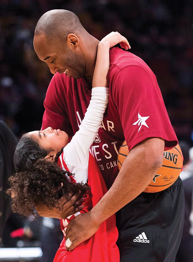 Kobe Bryant hugs his daughter, Gianna, on the basketball court during warm-ups before an NBA All-Star Game in Toronto on Feb. 14, 2016.
