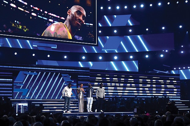 Grammy host Alicia Keys, second from left, and members of Boyz II Men, from left, Nathan Morris, Wanya Morris and Shawn Stockman, sing “It’s So Hard to Say Goodbye to Yesterday” during a tribute to late basketball star Kobe Bryant to open the award’s show Sunday night in Los Angeles. Below, Lizzo needs both hands to hold her awards won for best pop solo performance for “Truth Hurts;” best urban contemporary album for “Cuz I Love You;” and best traditional R&B performance for “Jerome.”