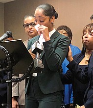 Jazmyne Childs, center, cries during a news conference in Raleigh, N.C., in September as she describes the sexual harassment she said she endured while working for the North Carolina State Conference NAACP. She filed a $15 million lawsuit Monday against the national NAACP, which she alleges condoned the behavior.