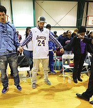 Dozens of people, many wearing Los Angeles Lakers T-shirts and paraphernalia, came out last Friday to remember Lakers superstar Kobe Bryant, his 13-year-old daughter, Gianna, and the seven others who were killed in a helicopter crash Jan. 26 in Southern California. The remembrance ceremony was led by Charles D. Willis, right, executive director of United Communities Against Crime, at the Black Top Kings & Queens Sports Academy in South Side.