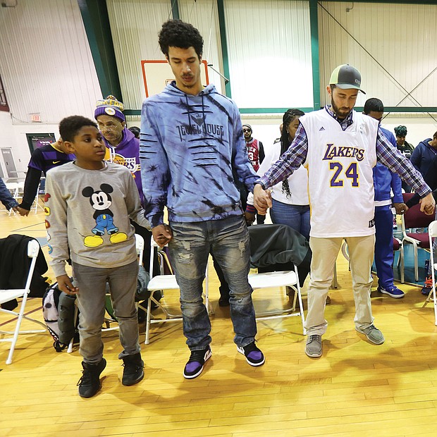 Dozens of people, many wearing Los Angeles Lakers T-shirts and paraphernalia, came out last Friday to remember Lakers superstar Kobe Bryant, his 13-year-old daughter, Gianna, and the seven others who were killed in a helicopter crash Jan. 26 in Southern California. The remembrance ceremony was led by Charles D. Willis, right, executive director of United Communities Against Crime, at the Black Top Kings & Queens Sports Academy in South Side.