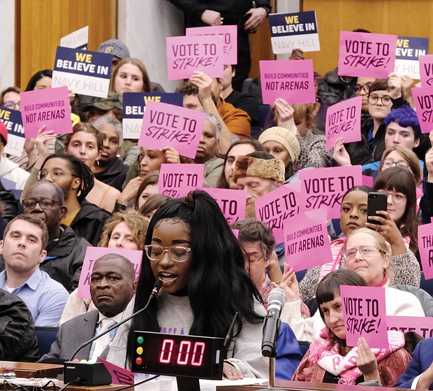 Naomi Isaac urges Richmond City Council to kill the $1.5 billion Coliseum replacement plan at Monday’s meeting. She was among a long line of people speaking on the proposal before council voted to scrap it. Behind her, supporters and opponents of the plan hold up signs reflecting their views.