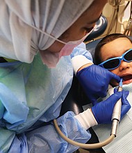 Bayron Rosales, 3, opens wide as Dr. Taibah AlBaker works on his mouth during VCu Dental Care Pediatric Dentistry’s annual day of free dental care last Friday at the Lyons Dental Building on 12th Street in Downtown. The effort was part of the American Dental Association’s annual “Give Kids A Smile” program begun in 2003 in which dentists, dental hygienists and dental assistants around the country volunteer their time and talents to provide free care to youngsters who otherwise would not have access to a dentist. In Richmond, pediatric dental specialists offered exams, cleanings, X-rays, fillings, extractions and minor restorations to youngsters without dental insurance. The national program kicks off National Children’s Dental Health Month.