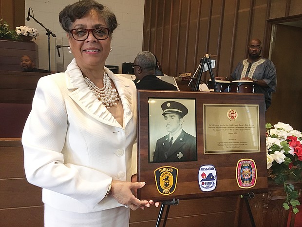 Raynell Reid shows off a tribute plaque to her late uncle, Richmond Fire Capt. Harvey S. Hicks II, during a ceremony last Sunday at Mosby Memorial Baptist Church. The ceremony marked the 70th anniversary of the hiring of the first 10 black firefighters in Richmond and Virginia. Capt. Hicks died June 4, 1963, attempting the daring rescue of a city resident who was trapped in a 23-foot-deep pit. The church joined with Engine Company No. 9 and Associates, a nonprofit group that works to call attention to the city’s pioneering black firefighters and police officers, on the Black History Month program. Richmond hired the first black police officers in 1946 and the first black firefighters in 1950. At the time of his death, Capt. Hicks also was studying for the ministry and was to preach his trial sermon a few days later. As part of Sunday’s commemoration, Dr. Price L. Davis, pastor of the church at 2901 Mechanicsville Turnpike, preached the sermon that the firefighter had written.